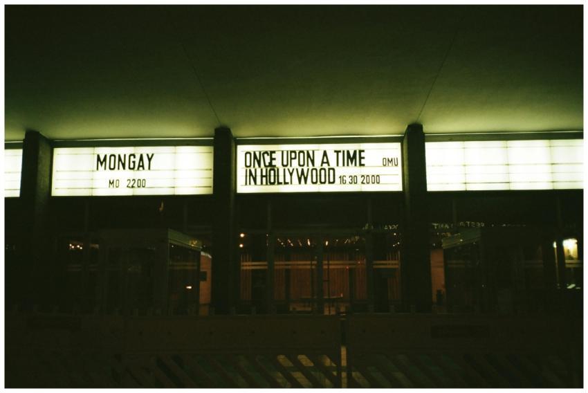 Outdoor view of an illuminated theater marquee dis