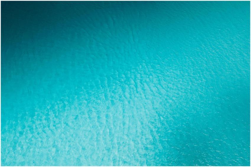 A serene aerial photograph of a textured turquoise