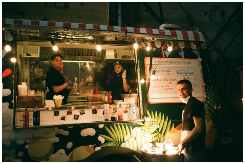 Street food truck illuminated at night with staff