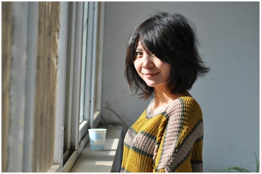 A young woman with a bob hairstyle smiles warmly w
