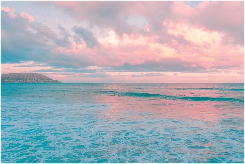 Pink and blue hues merge over an island seascape d