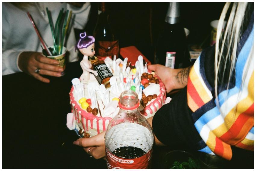 A vibrant cake with candy decorations and a doll t