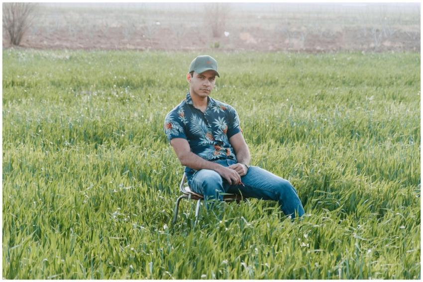 Casually dressed man in a vibrant green field enjo