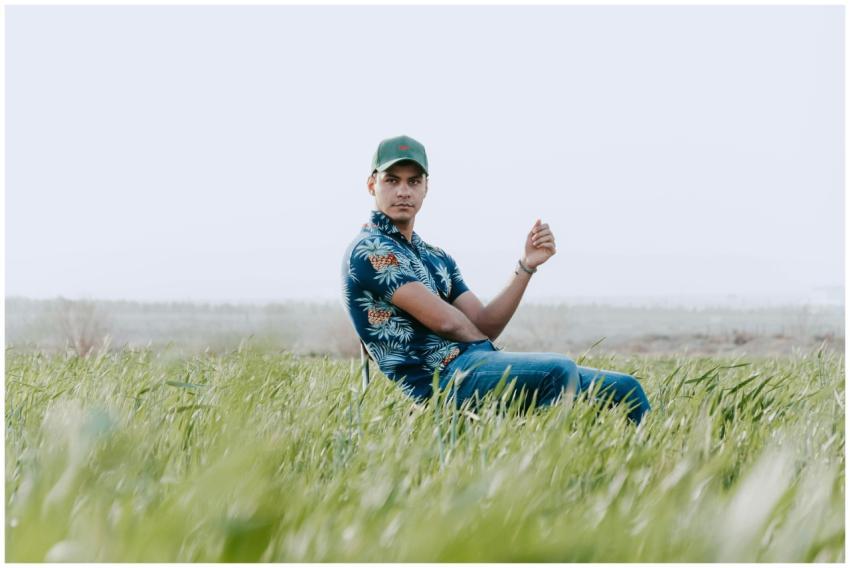 A young man in casual clothing sits serenely in a