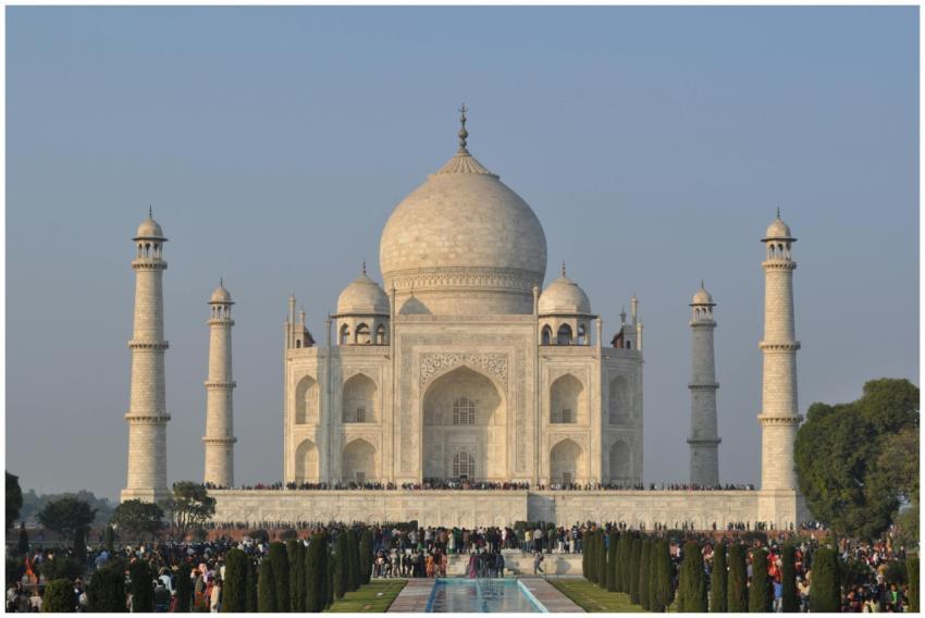 The iconic Taj Mahal with a clear blue sky, surrou