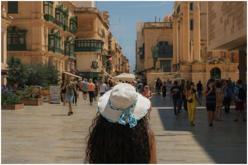 A woman in a wide-brimmed hat explores the bustlin