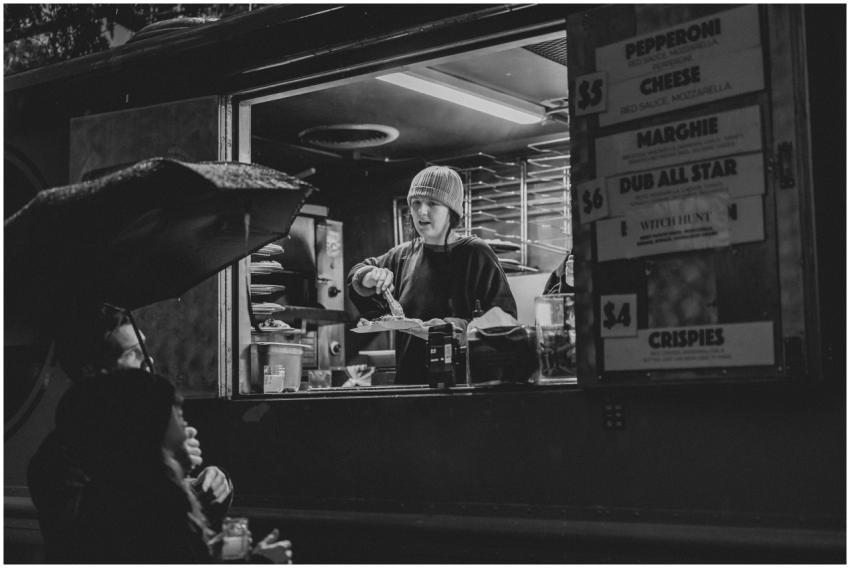 Black and white photo of a street food vendor serv