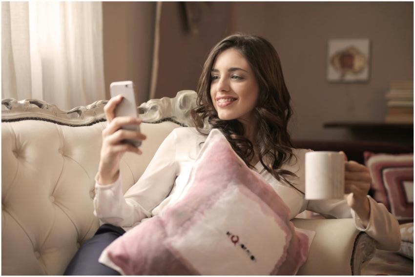 A young woman relaxing on a sofa, enjoying coffee