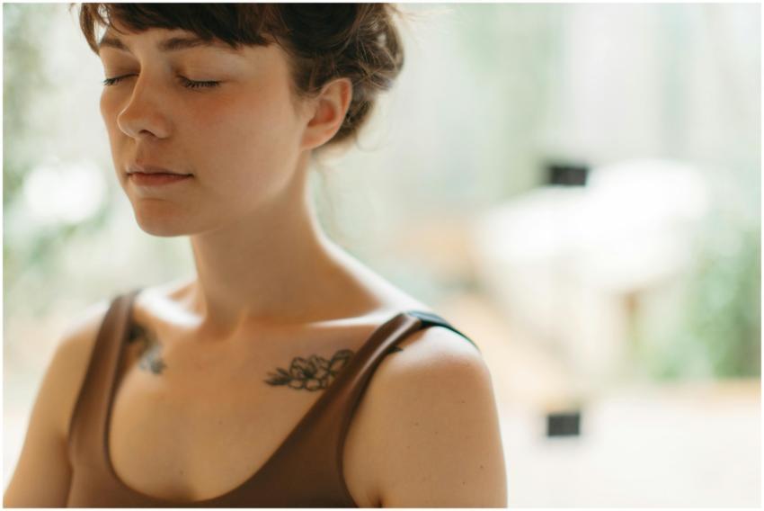 Woman with closed eyes meditating indoors, symboli