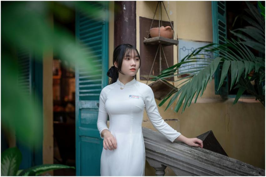 Portrait of a young woman in white ao dai, standin