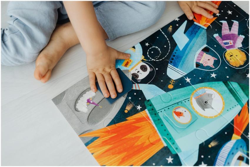 A young child solves a colorful space-themed jigsa