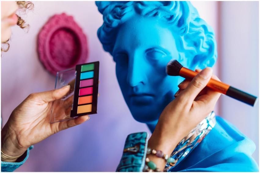 Vibrant makeup application on a blue statue bust,