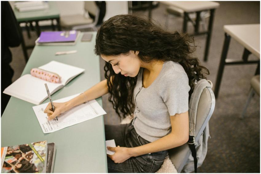 Young college student writing on test paper in a c