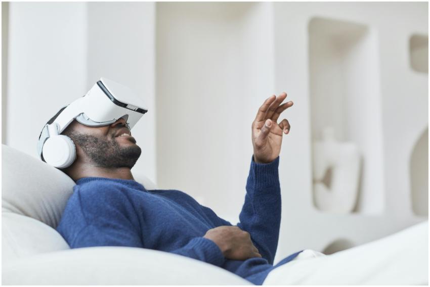 Relaxed African American man using VR headset indo