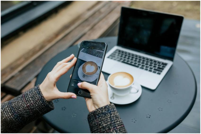 Person snaps a photo of a latte using a smartphone