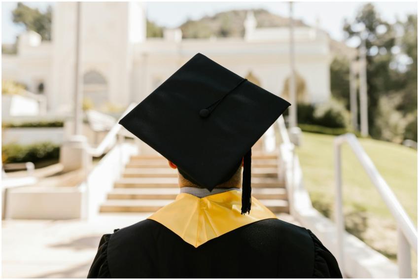 Back view of a graduate in a cap and gown standing