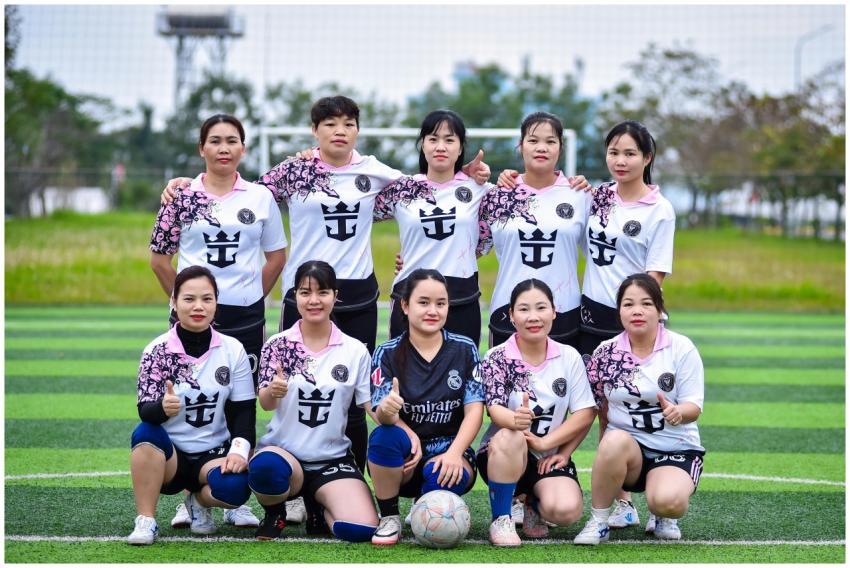 A women's football team in Hanoi, Vietnam, poses o