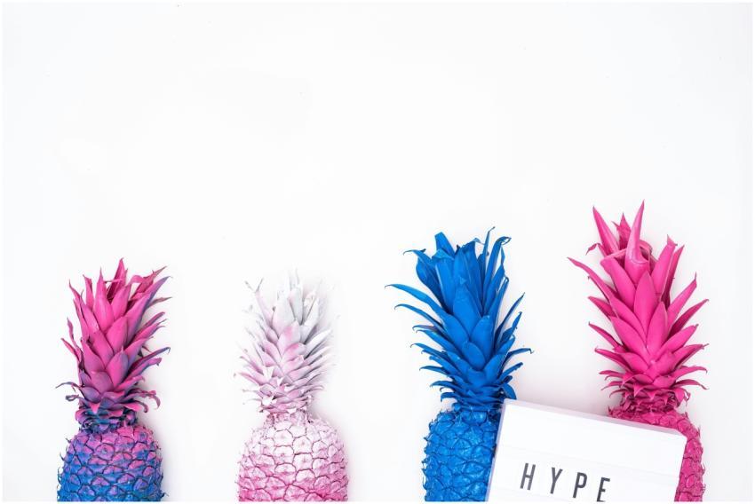 Colorful painted pineapples against a white backdr