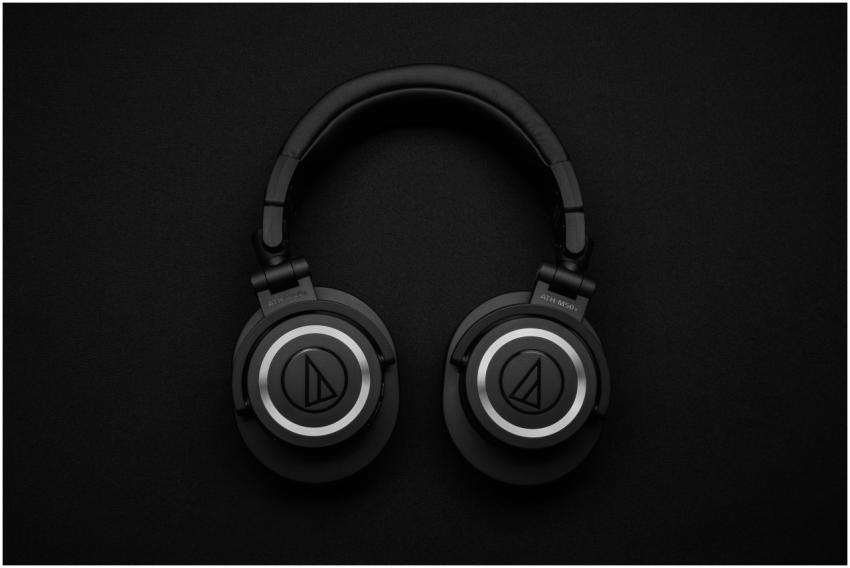 Close-up of black over-ear headphones on a black b