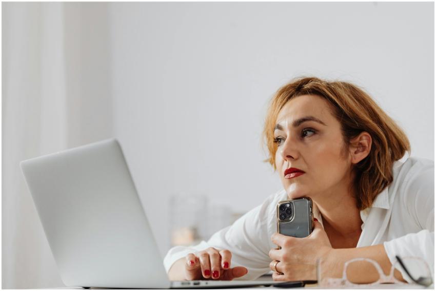 Businesswoman using laptop and mobile phone at mod