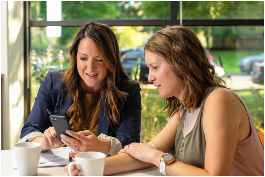 Two women discussing business ideas while looking
