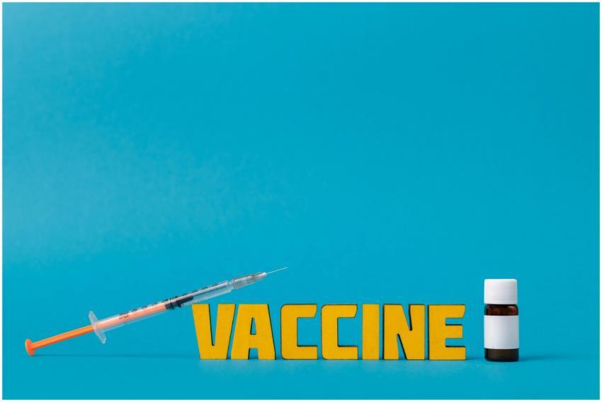 A bright image showcasing a syringe and vaccine bo