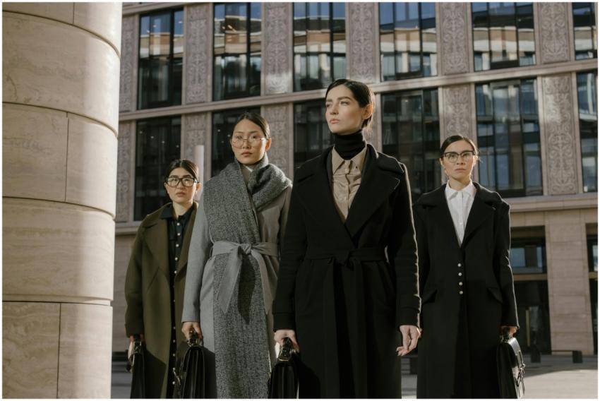 Four confident women in coats with briefcases outs
