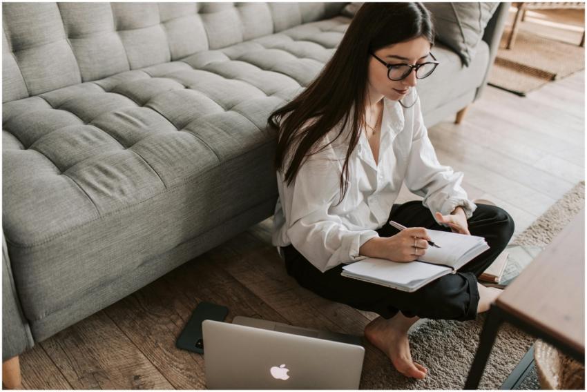 A young woman sitting on the floor using a laptop