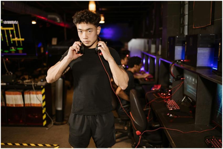 A serious young man in a gaming lounge with headph