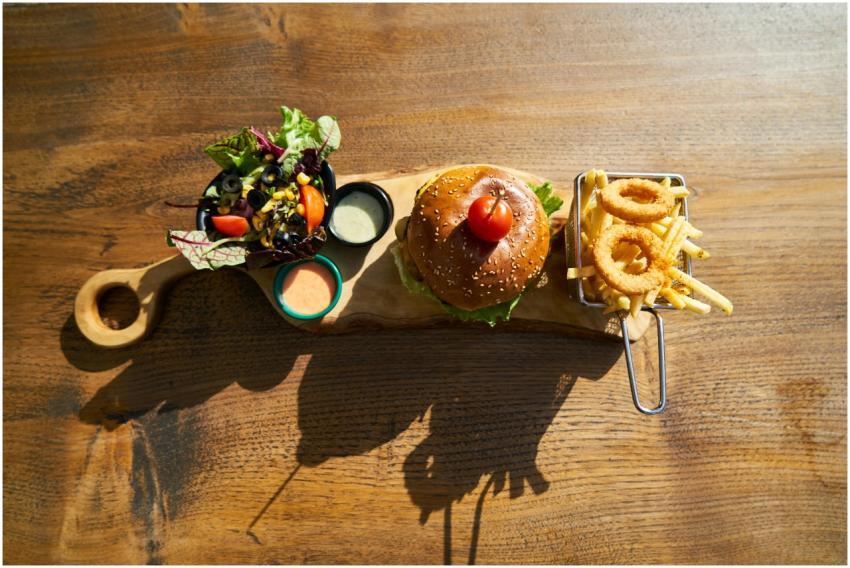 Delicious gourmet burger served with salad, fries,