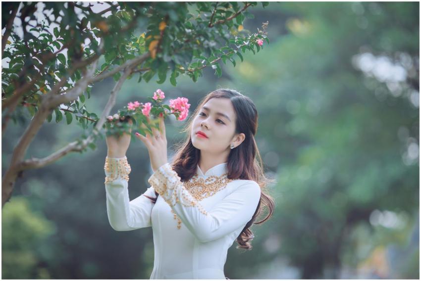 An elegant woman in traditional Ao Dai appreciatin