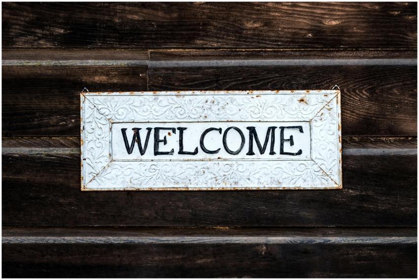 A rustic vintage-style 'Welcome' sign on a wooden
