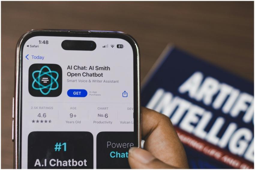 Hand holding a smartphone with AI chatbot app, emp