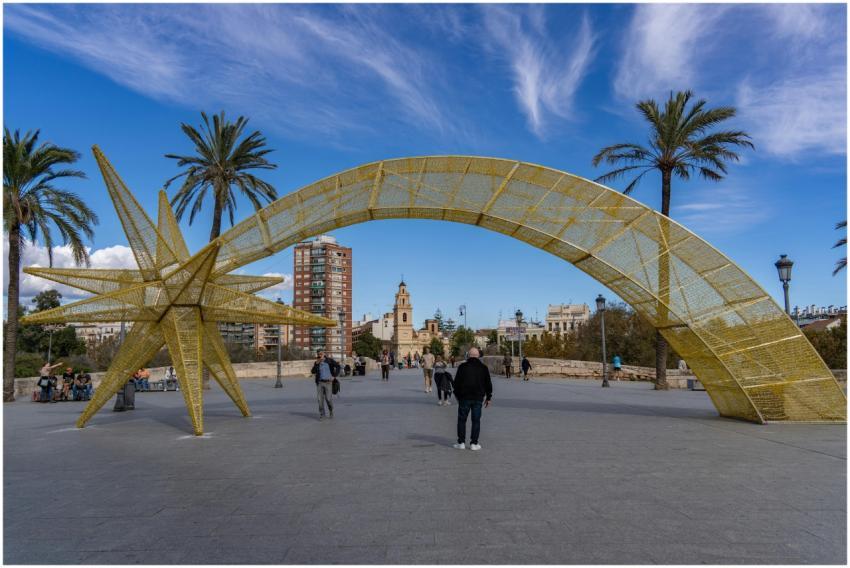 Golden star sculpture and arch in a vibrant plaza