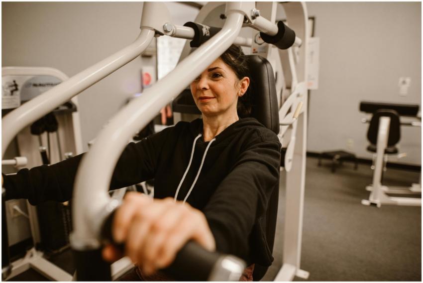 Woman working out on gym equipment focusing on fit