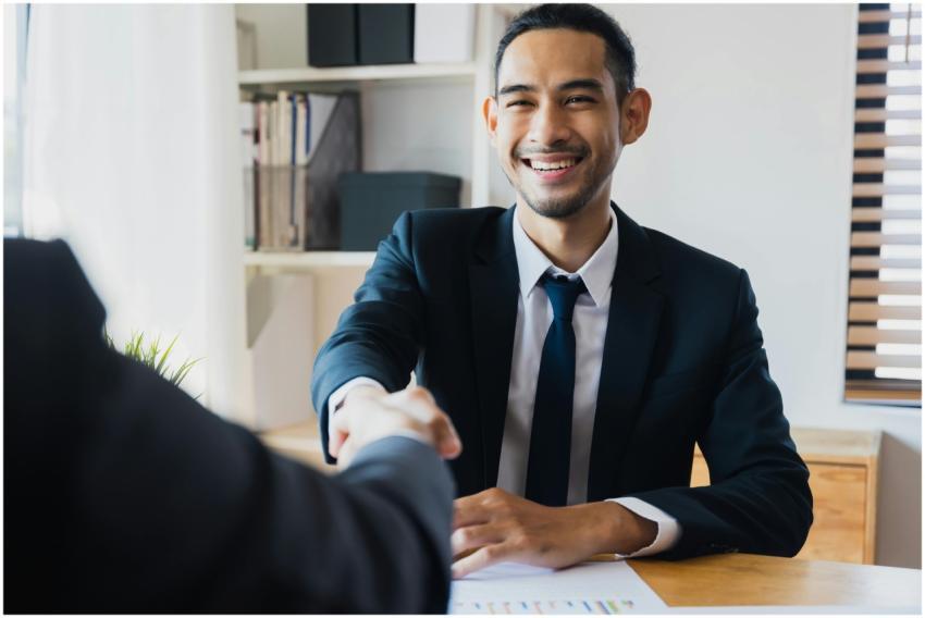 Confident businessman in suit shaking hands at off
