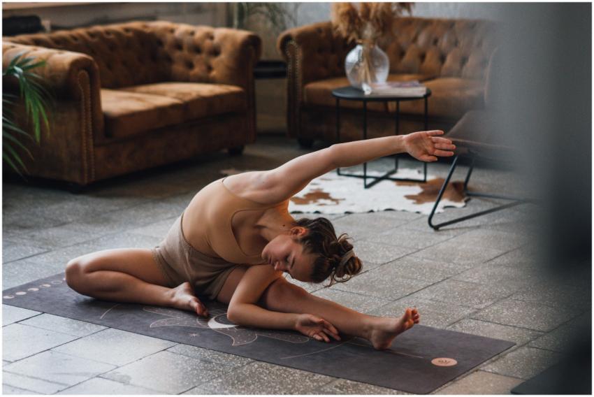 Woman practicing yoga indoors, showcasing flexibil