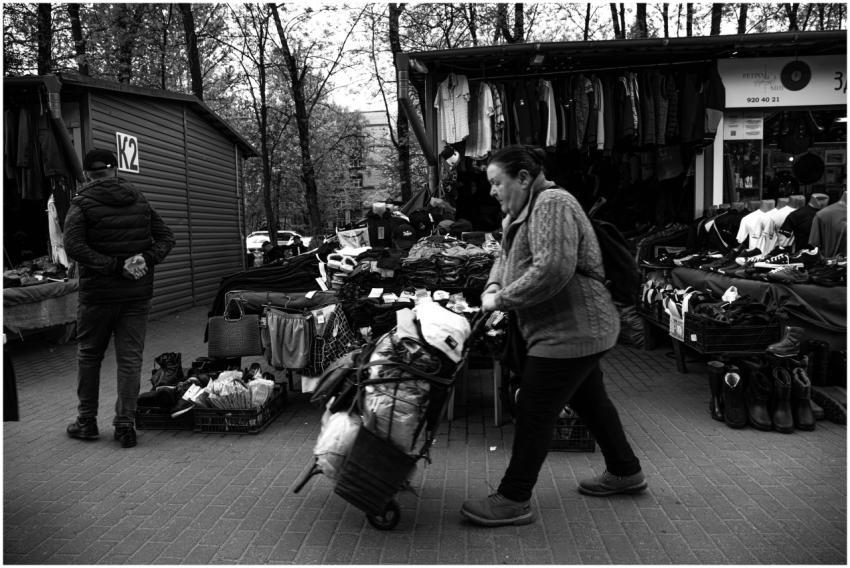 Black and white image of a woman pushing a cart am