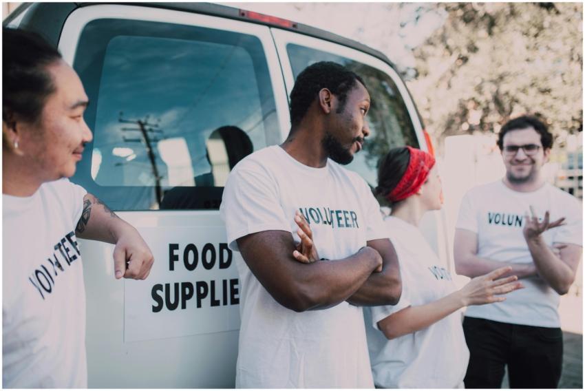 Volunteers gather beside a van to prepare and dist