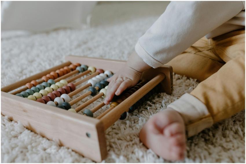Toddler engaging with a wooden abacus on a fluffy