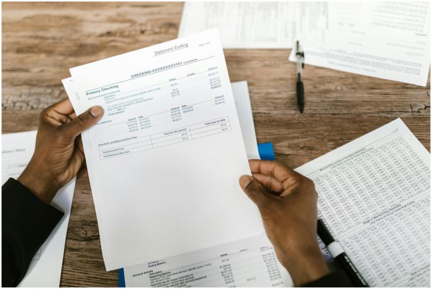 Hands holding financial papers for tax preparation