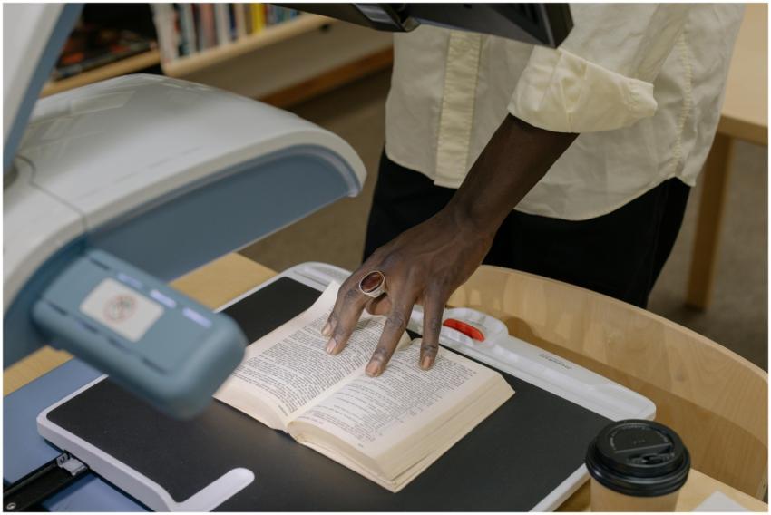 An anonymous individual scans a book in a library