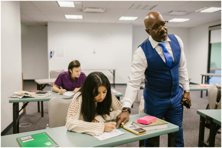 Teacher monitors students during an exam in a clas
