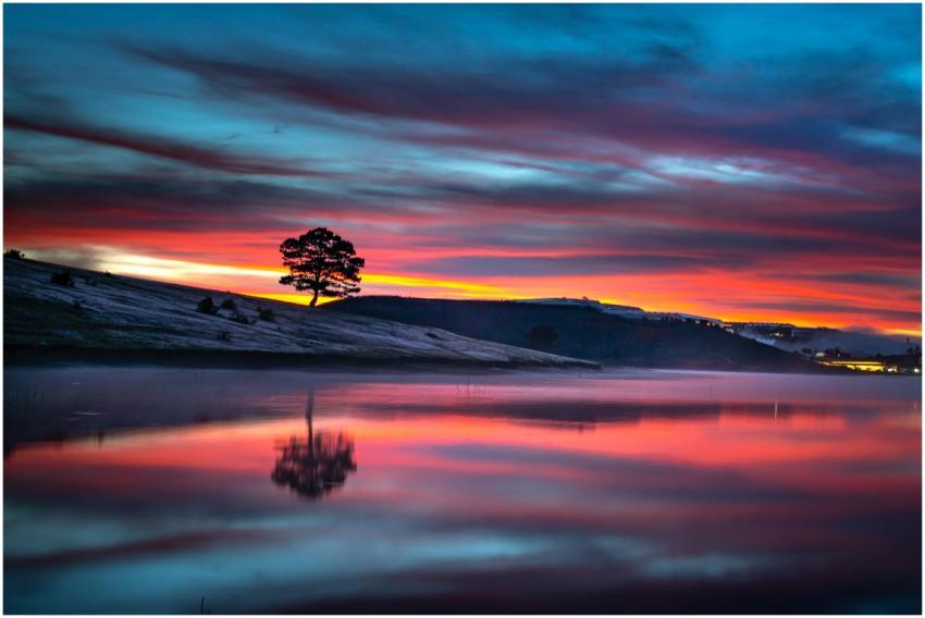Stunning sunset over a tranquil lake with vibrant