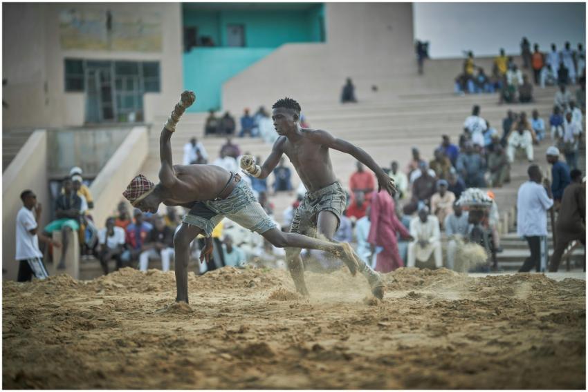 Action-packed scene of two men wrestling in a sand