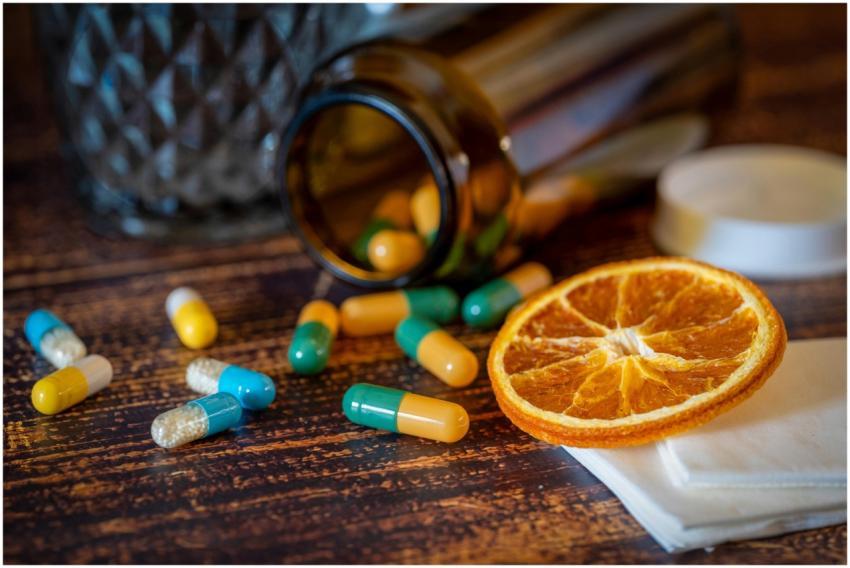 Close-up of vitamins, pills, and dried orange slic