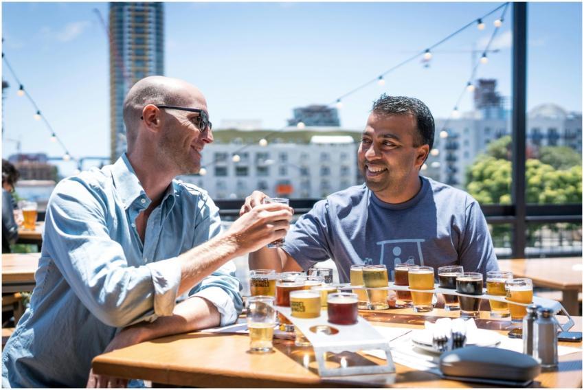 Two friends clinking glasses during a craft beer t