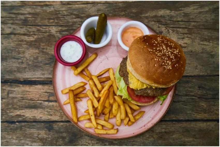 Top view of a tasty cheeseburger served with fries
