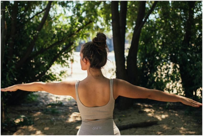 Back view of a young woman in activewear practicin