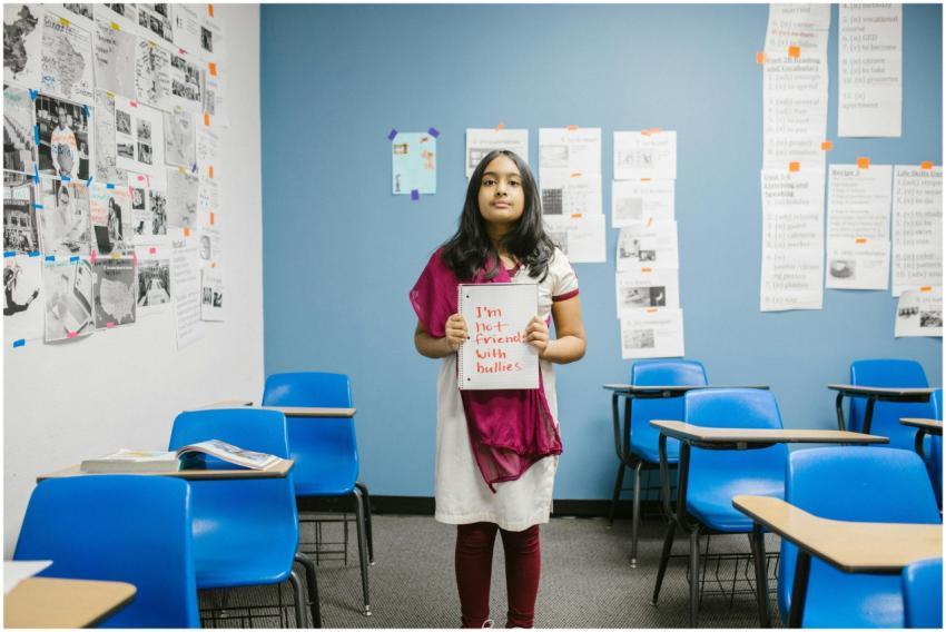 A young girl holding a sign promoting anti-bullyin